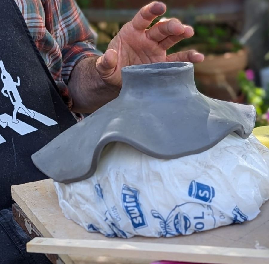 Hände an einer Vase über einer Form